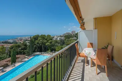 a balcony with a table and chairs and a swimming pool at Le rêve bleu in Nice