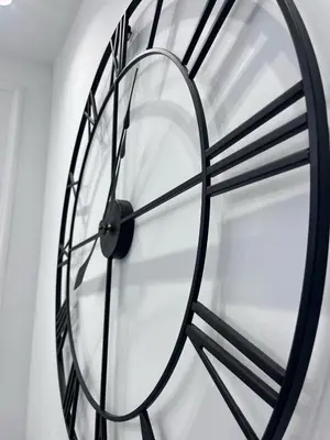 a large black clock hanging on a wall at RF104 - Charmant 3P à nice près du Port in Nice