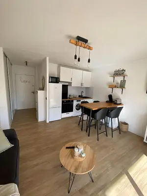 a living room and kitchen with a table and chairs at Studio cosy proche de la mer in Nice