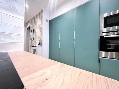 a kitchen with blue cabinets and a wooden counter top at RF101- Magnifique 3 pièces centre Nice in Nice