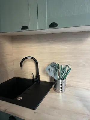 a kitchen counter with a sink and a pot of utensils at Studio confort proche du port in Nice