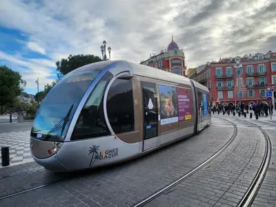a silver train on the tracks in a city at AERO Nice in Nice