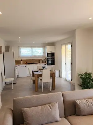 a living room and kitchen with a couch and a table at Superbe appartement vue mer in Cagnes-sur-Mer