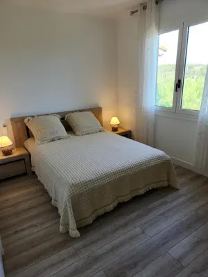 a white bedroom with a bed and two windows at Superbe appartement vue mer in Cagnes-sur-Mer