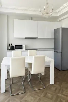 a white kitchen with a white table and white chairs at Splendide appartement design plein centre nice climatisé - 3 chambres in Nice