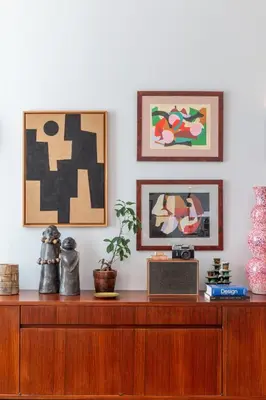 a wooden dresser with two pictures on the wall at Elegant apartment, Cap de Nice in Nice