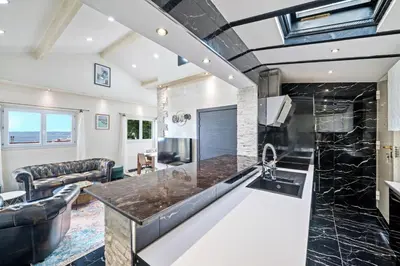 a kitchen with a large island in a living room at Villa Nissarda, Maison Niçoise avec vue mer, parking, à 5 minutes du port in Nice