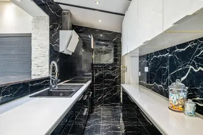 a kitchen with black marble counters and a sink at Villa Nissarda, Maison Niçoise avec vue mer, parking, à 5 minutes du port in Nice
