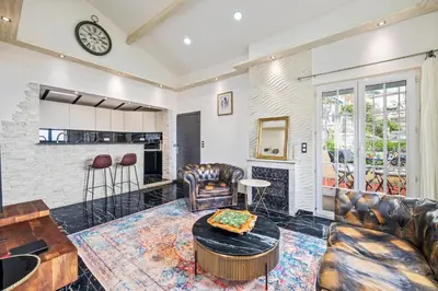 a living room with leather furniture and a fireplace at Villa Nissarda, Maison Niçoise avec vue mer, parking, à 5 minutes du port in Nice