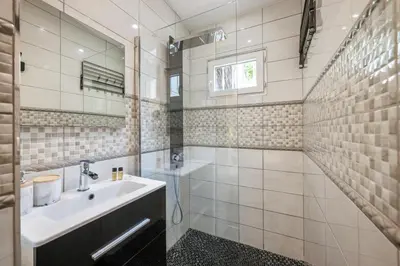 a white bathroom with a sink and a mirror at Villa Nissarda, Maison Niçoise avec vue mer, parking, à 5 minutes du port in Nice