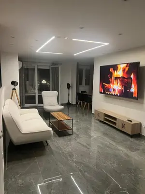 a living room with a couch and a tv on a wall at Appartement Luxe & design Vue mer sur la Promenade des Anglais in Nice