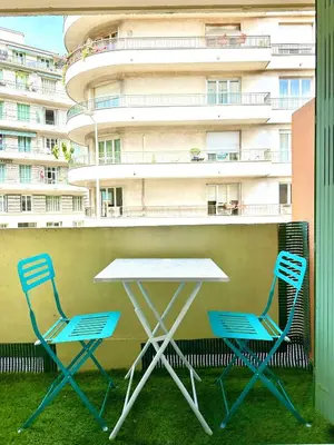 two chairs and a table on a balcony with a building at Studio Riviera - balcon et Wifi in Nice