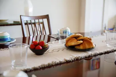 a table with a plate of bread and a bowl of strawberries at Palais D'orient in Nice
