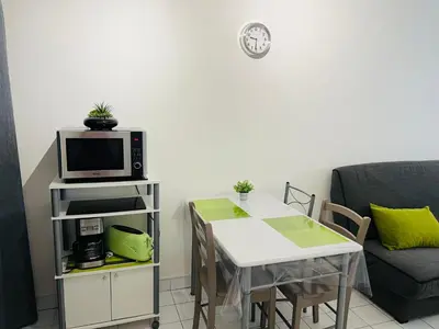 a living room with a table and a microwave at Magnan et ses plages de la Promenade des Anglais in Nice