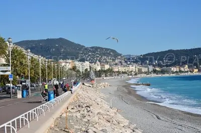 a woman is standing in front of a large sign at Magnan et ses plages de la Promenade des Anglais in Nice