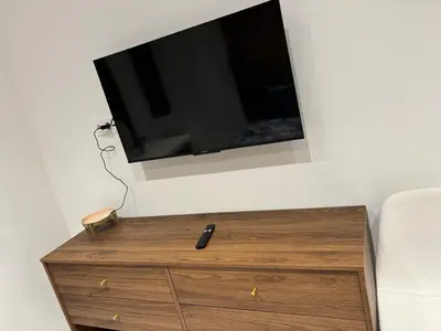 a tv on a wall above a wooden dresser at Beautiful and super central in Nice