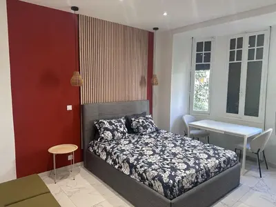 a bedroom with a bed and a table and a desk at Beautiful and super central in Nice