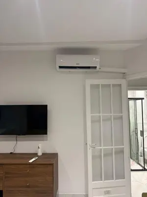 a living room with a tv and a white wall at Beautiful and super central in Nice