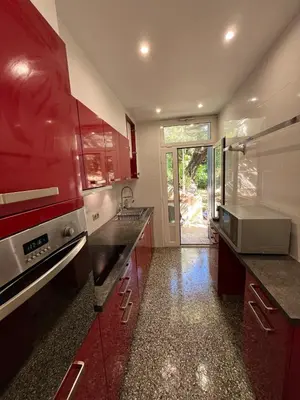 a kitchen with red cabinets and a sink at Seaside Jungle Retreat in Nice