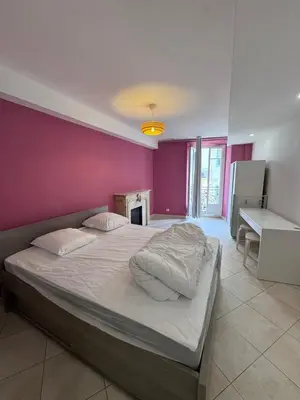 a bedroom with a large bed with a pink wall at Beau 4 pièces - hyper centre 8 couchages in Nice