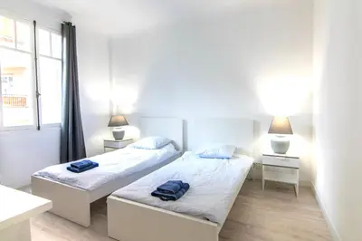 a bedroom with two beds and two lamps and a window at Résidence Estienne d'Orves in Nice