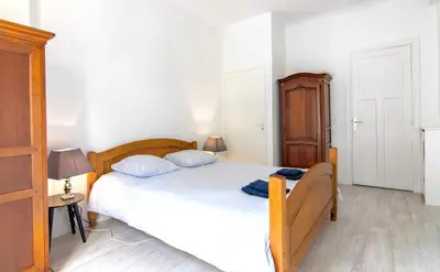 a bedroom with a bed and a wooden cabinet at Résidence Estienne d'Orves in Nice