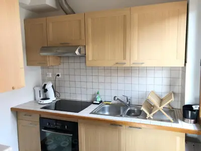 a kitchen with wooden cabinets and a sink at Cosy Studio Sea view in Villefranche-sur-Mer