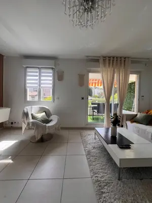 a living room with a couch and a chandelier at Appartement rénové , Climatisé, Terrasse, Parking en sous sol in Saint-Laurent-du-Var