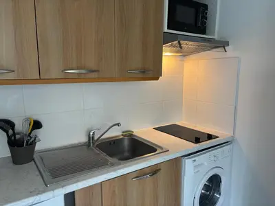 a kitchen with a sink and a washing machine at Studio Calif, face tram proche Mer in Nice