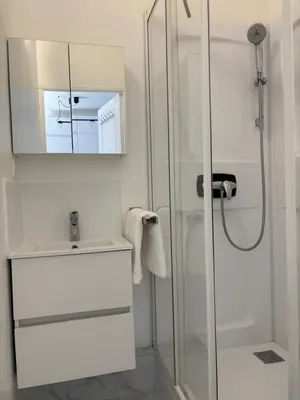 a white bathroom with a sink and a shower at Studio Proche Tram accès Centre Ville Plage in Nice