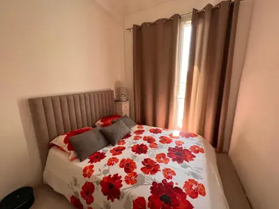 a bedroom with a bed with red flowers on it at Lovely apartment nice in Nice