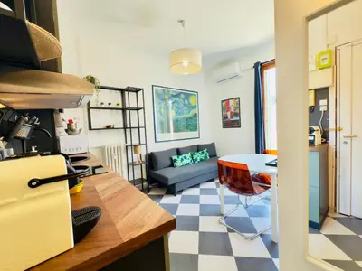 a kitchen and living room with a couch and a table at New Alba 3 Pers WiFi AC in Nice