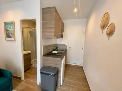 a small kitchen with a trash can in a room at Studio calme et central avec clim in Nice
