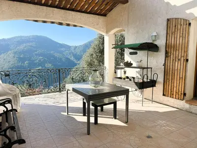 a table on a balcony with a view of a mountain at Maison Familiale 3 chambres Cœur de la Nature in Drap