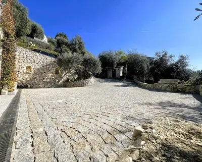 a cobblestone street with trees and a stone wall at Maison Familiale 3 chambres Cœur de la Nature in Drap