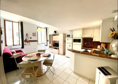 a kitchen and living room with a table and chairs at 2 pièces avec clim proche place Masséna in Nice