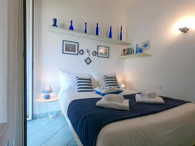 a bedroom with a bed with blue vases on the wall at Le Marie Jeanne 6 Pers Giardino Vista Mare in Villefranche-sur-Mer