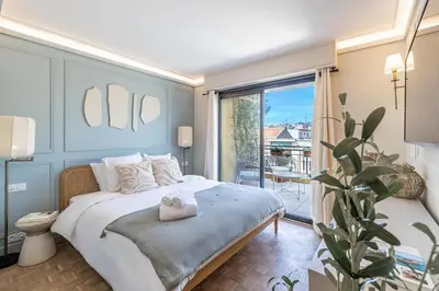 a bedroom with a large bed and a balcony at Luxurious penthouse, 2 bedroom suites, 3 spacious terraces, gorgeous views of mountains and sea, in Nice