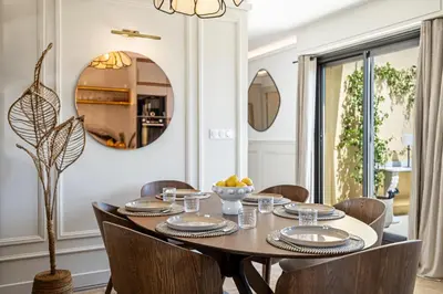 a dining room with a table and chairs and a mirror at Luxurious penthouse, 2 bedroom suites, 3 spacious terraces, gorgeous views of mountains and sea, in Nice