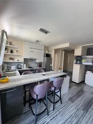 a kitchen with a large counter with purple chairs at Elegant Apartment Terrace Port of Nice in Nice