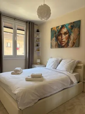 a bedroom with a large white bed with towels on it at Elegant Apartment Terrace Port of Nice in Nice