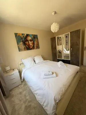 a bedroom with a large white bed with a painting on the wall at Elegant Apartment Terrace Port of Nice in Nice