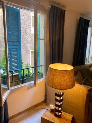 a lamp sitting on a table next to a window at Au cœur du Vieux Nice, 3 chambres au calme, grand appartement in Nice