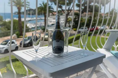 a bottle of wine sitting on a table with two glasses at 3P ST Jean in Saint-Jean-Cap-Ferrat