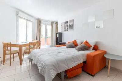 a bedroom with a large bed and a dining room at HAPPYFEW Le Palais des Arts in Nice