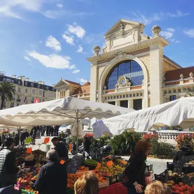a market in front of a large building with fruits and vegetables at Cosy appartement gare du sud - Nice - 3 guests in Nice