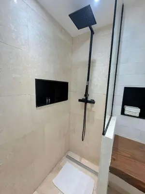 a bathroom with a shower with a television on the wall at ⁂ Studio Vieux-Nice climatisé: charme commodités in Nice