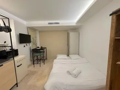 a small room with two beds and a table at ⁂ Studio Vieux-Nice climatisé: charme commodités in Nice