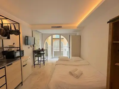 two beds in a room with a kitchen and a sink at ⁂ Studio Vieux-Nice climatisé: charme commodités in Nice