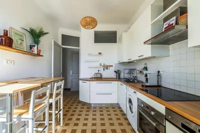 a kitchen with white appliances and a wooden counter top at 3 pieces lumineux avec balcon au coeur de la ville in Nice